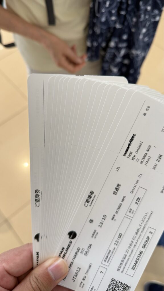 石垣旅行の搭乗券。家族分の石垣から那覇へ向かう便の航空チケットを手に持つ様子