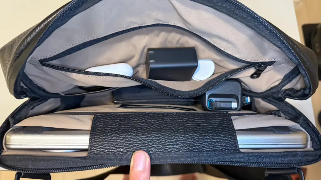 Inside view of the GRAMS28 171 Laptop Sling holding a 14-inch MacBook Pro, power bank, and daily essentials.