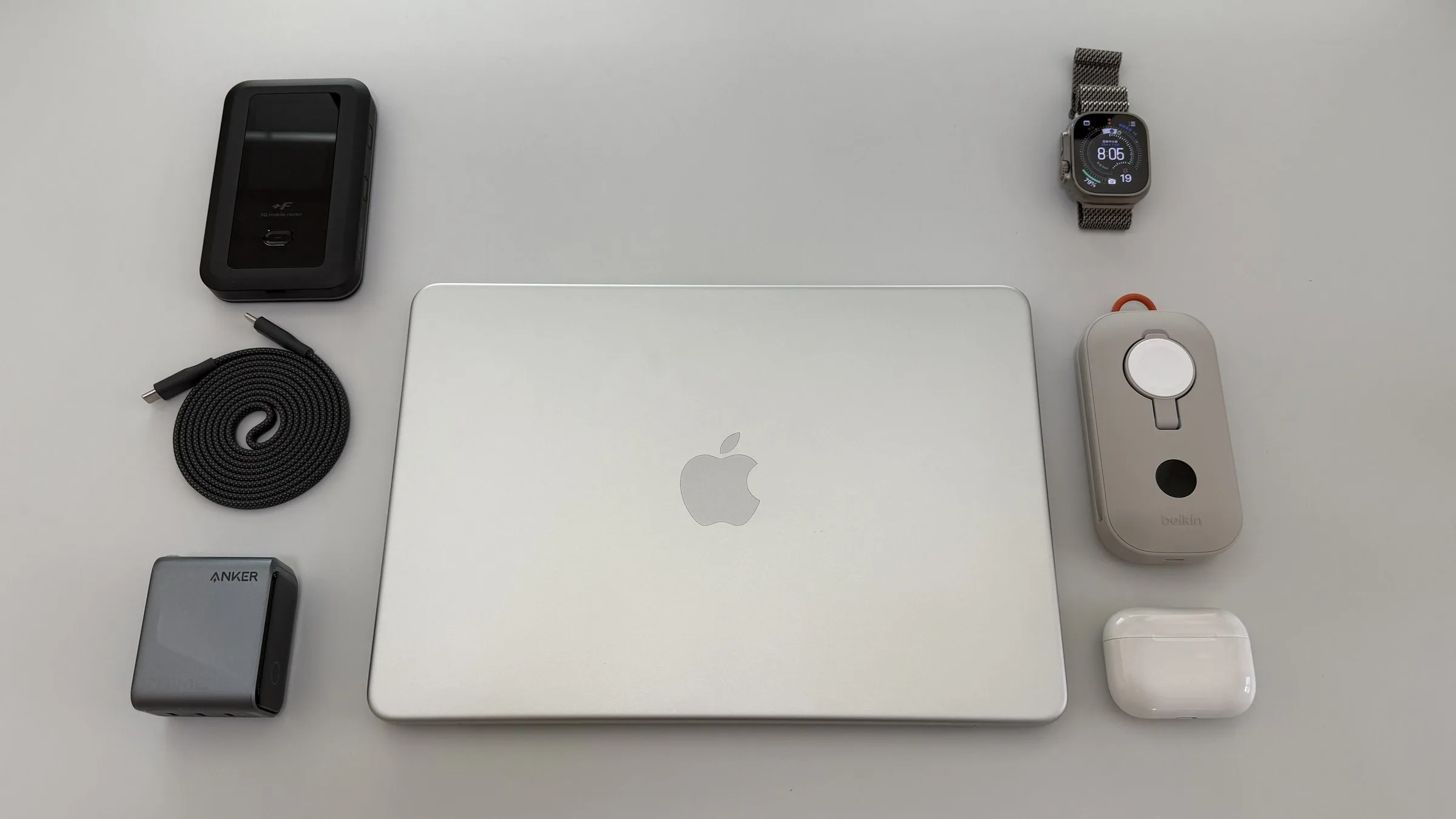 MacBook Neo、Apple Watch Hermès Ultra 3、AirPods Pro 3、Anker Prime Charger 160W、Belkin BoostCharge Pro、CIO Mate Flat Spiral Cable、+F FS050Wを並べたApple信者の毎日の持ち物2026年版のフラットレイ写真